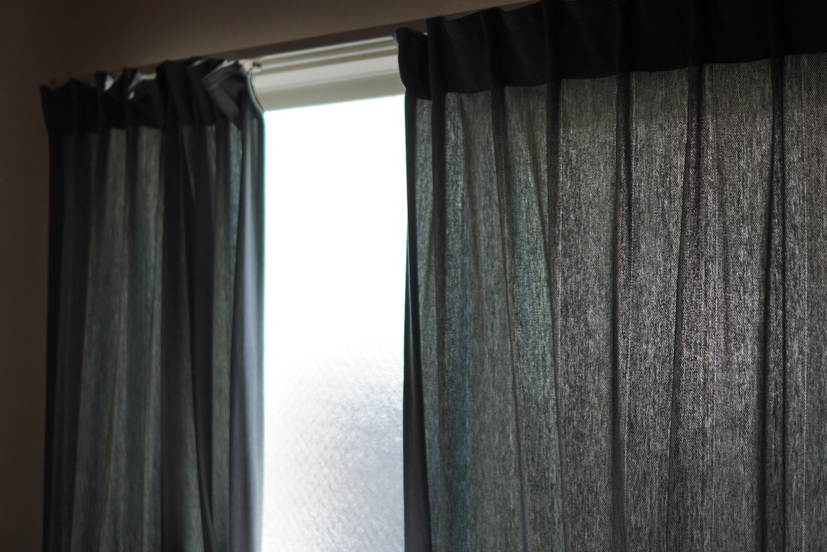 朝の光が差し込むカーテン。整えすぎない選択や判断基準を考える時間のイメージ